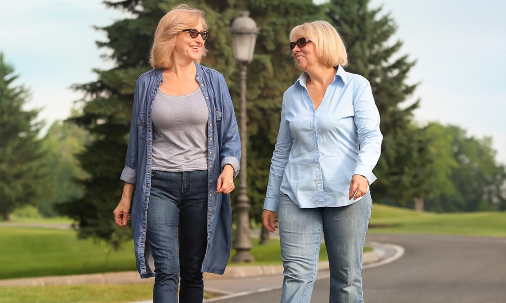 two women walking on the street smiling